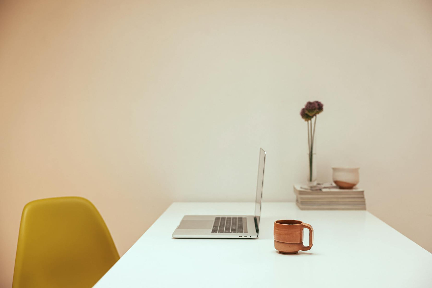 A serene minimalist workspace featuring a laptop and coffee on a white desk. on The Digital Hustler