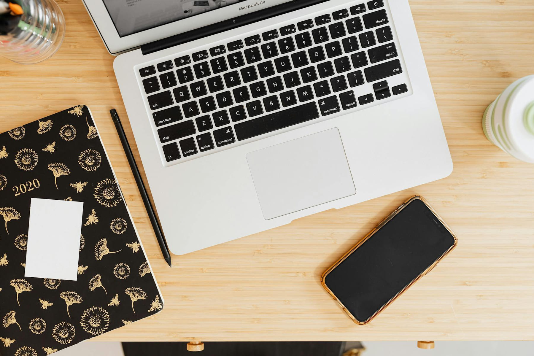 Flat lay of laptop, smartphone, and notebook on a wooden desk. on The Digital Hustler