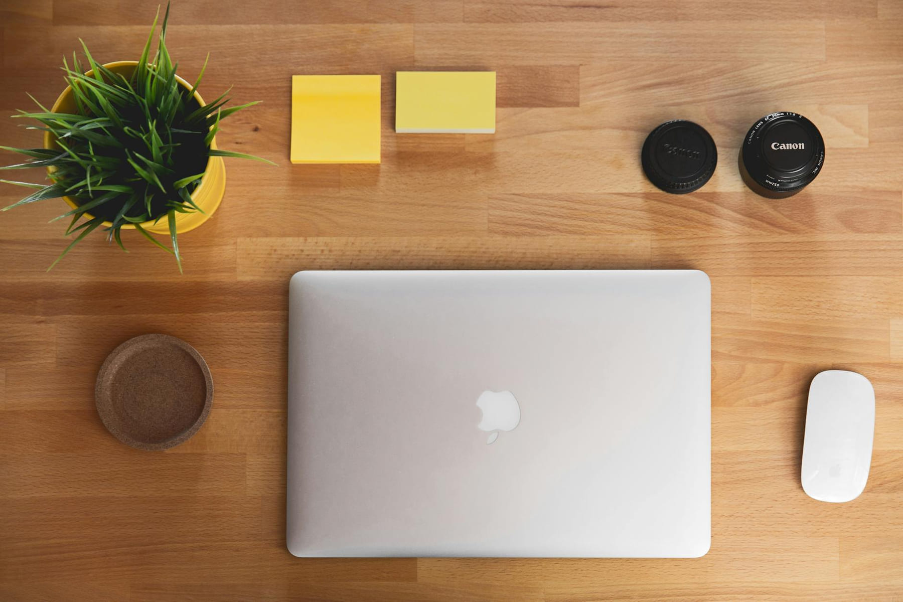 A top-down view of a clean wooden workspace with a laptop, plant, and accessories. on The Digital Hustler