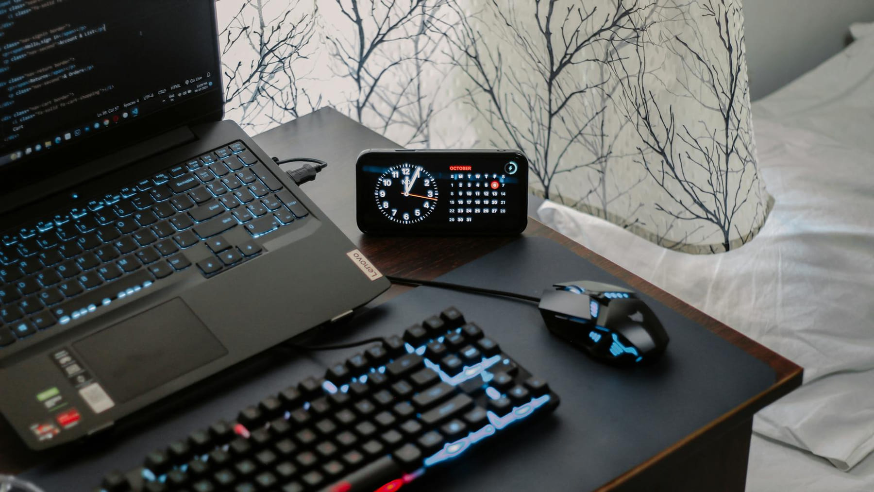 A modern workspace featuring a laptop, digital clock, gaming mouse, and keyboard, ideal for work and tech enthusiasts. on The Digital Hustler