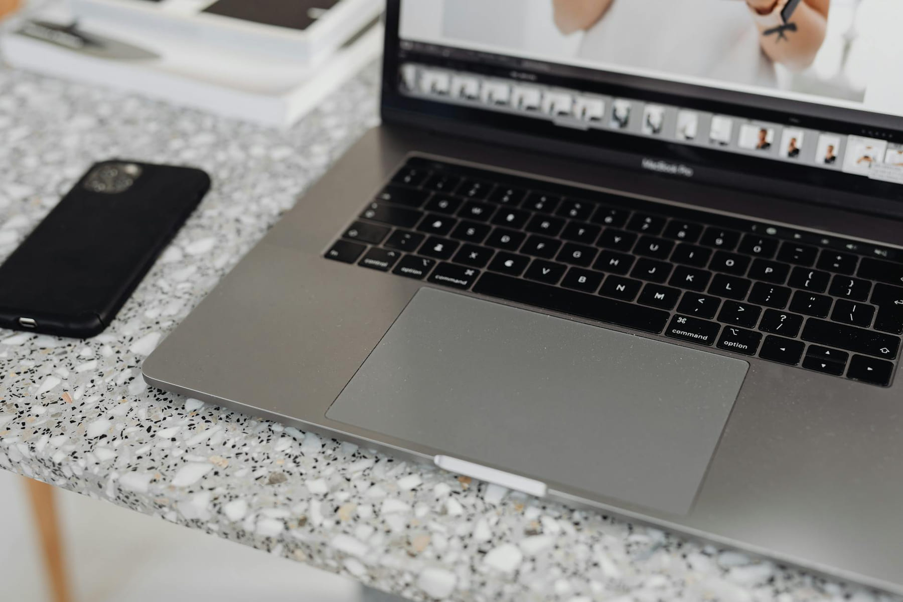 Close-up of a laptop and smartphone on a terrazzo surface, showcasing modern workspace essentials. on The Digital Hustler