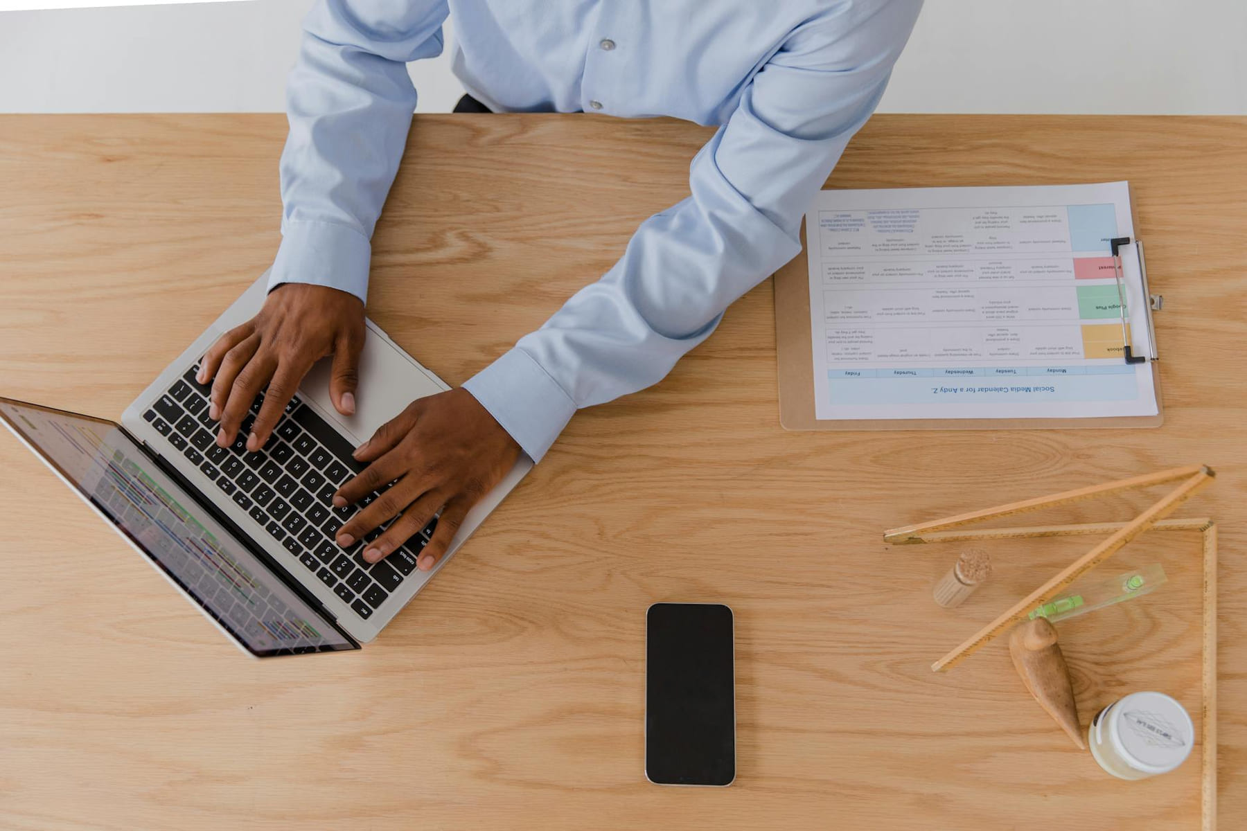 Top-down view of a man in business attire working on a laptop at a desk. on The Digital Hustler